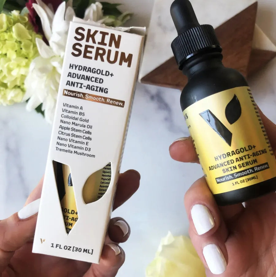 Hands holding the Hydragold+ serum bottle and its carton listing the key ingredients